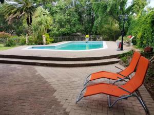 a orange chair sitting next to a swimming pool at Che La Moir Guesthouse in Bloemfontein