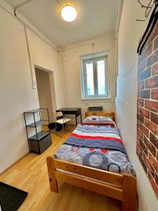 een bed in een kamer met een bakstenen muur bij Bene Dormies in Praag