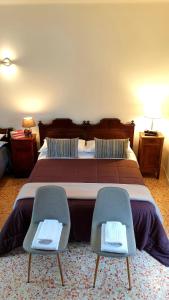 クレモナにあるbb26 Buoso apartment city centerのベッドルーム1室(大型ベッド1台、椅子2脚付)