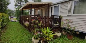 a fence with potted plants in front of a house at mobile home for you Les Rives de Condrieu in Condrieu