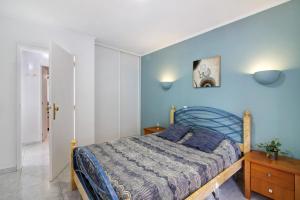 - une chambre avec un lit et un mur bleu dans l'établissement Lemons Apartment, à Carvoeiro