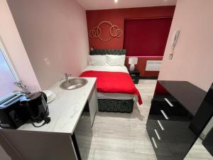 a small room with a bed with a sink at Private Family and Business Rooms Harrow Fast WiFi in Pinner