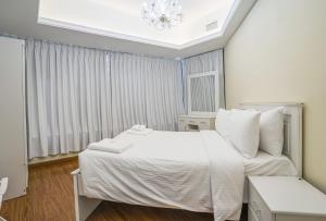 a bedroom with a white bed and a chandelier at ZAPBED House - AWP 1501 in Dubai +43 photos