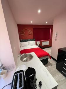 Letzi Private En-Suite In Harrow في Pinner: غرفة نوم مع سرير بورد احمر الراس
