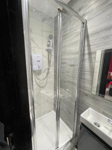 eine Dusche mit Glastür neben einem Waschbecken in der Unterkunft Letzi Private En-Suite In Harrow in Pinner