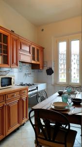クレモナにあるbb26 Buoso apartment city centerのキッチン(木製キャビネット、木製テーブル、テーブル付)