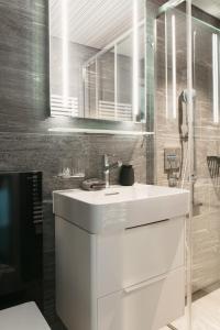 ein Badezimmer mit einem weißen Waschbecken und einer Dusche in der Unterkunft Centro Magliaso in Magliaso