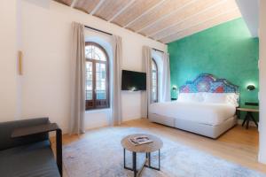 a bedroom with a white bed and a green wall at Cavalta Boutique Hotel GL in Seville