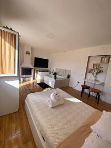 Habitación blanca grande con cama y TV. en Casa vacanza “oasi” en Salerno