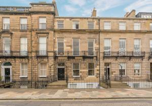 ein großes Backsteingebäude mit Treppen davor in der Unterkunft Melville Street Apartment in Edinburgh