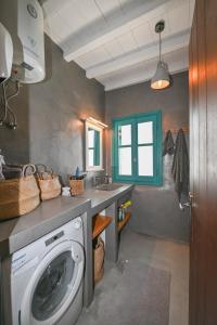 a bathroom with a washing machine and a sink at Tinos Traditional Patio House in Arnados