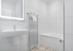 a white bathroom with a sink and a bath tub at High Street Apartment in Edinburgh +29 photos