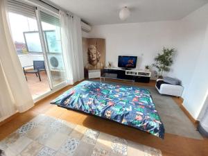 1 dormitorio con una alfombra grande y colorida en el suelo en Ático de Laura, en Armilla