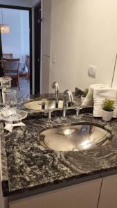 a bathroom sink with two faucets on a counter at Departamento frente a lago Carlos Paz - Villa Siquiman - Complejo Veneto Village in Villa Parque Siquiman