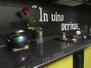 Elena's room في باتومي: طاولة مطبخ مع وردة في مزهرية على موقد