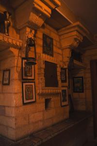 a stone wall with framed pictures on it at Hotel Victoria in Jaisalmer