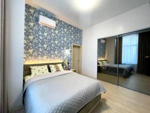 1 dormitorio con 1 cama con pared azul en Central street, en Járkov