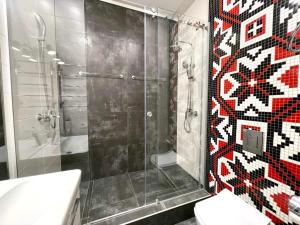 ein Bad mit einer Dusche und einer Mosaikwand in der Unterkunft Central street in Kharkov