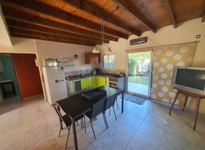 une cuisine avec une table et des chaises et une télévision dans l'établissement ÀYRES PAMPA I PB, à Las Gaviotas