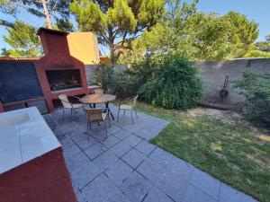 un patio avec une table, des chaises et une cheminée dans l'établissement ÀYRES PAMPA I PB, à Las Gaviotas 5 autres photos