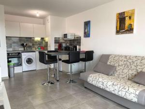 a living room with a couch and a table and a kitchen at Appartement T2 avec balcon, parking privé, wifi - Balaruc-les-Bains - FR-1-553-204 in Balaruc-les-Bains +6 photos