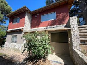 une maison rouge avec un garage dans l'établissement ÀYRES PAMPA I PB, à Las Gaviotas