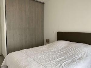 a bedroom with a large white bed in it at Appartement T2 avec balcon, parking privé, wifi - Balaruc-les-Bains - FR-1-553-204 in Balaruc-les-Bains