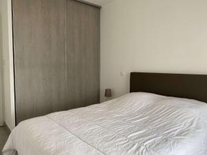 um quarto com uma grande cama branca em Appartement Balaruc-les-Bains, 2 pièces, 2 personnes - FR-1-553-204 em Balaruc-les-Bains