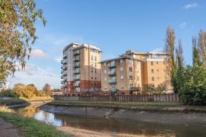 a couple of tall buildings next to a river at Modern Apartment Near Train Station in Ipswich