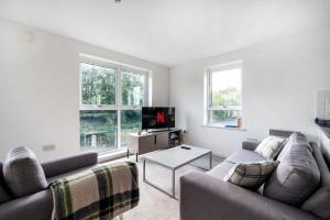a living room with two couches and a tv at Modern Apartment Near Train Station in Ipswich