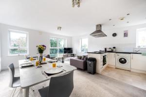 een keuken en een woonkamer met een tafel en stoelen bij Modern Apartment Near Train Station in Ipswich