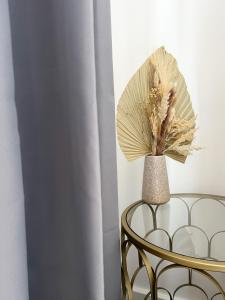 a vase with a fan sitting on a chair next to a curtain at London Stylish 1 Bedroom Apartment in London