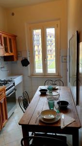 クレモナにあるbb26 Buoso apartment city centerのキッチン(木製テーブル、皿付)