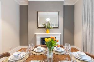 a dining room with a table and a fireplace at Spacious Private home with King sized bed and Garden newly renovated in London