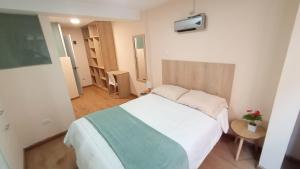 1 dormitorio con 1 cama blanca grande en una habitación en MADA Guest House Puno "Hospedaje", en Puno