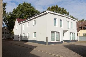 a white house on the side of a street at CABANA - Maisonette Apartments - Parkplatz - WiFi kostenlos - Nähe Klinikum in Oldenburg
