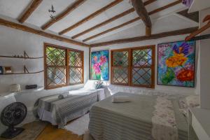 a bedroom with a bed and a bath room at Casa Atelie Bangue in Ilhabela