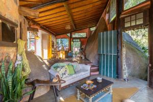 a living room with a couch and a table at Casa Atelie Bangue in Ilhabela