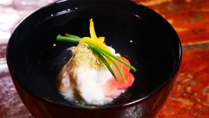 uma tigela preta de alimentos com carne e legumes em ほたるの長屋 em Yamaga