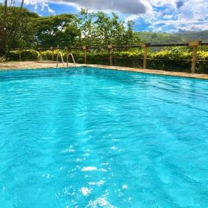 uma grande piscina com água azul em Chácara Morada do Sol - (pé na represa) em Igaratá