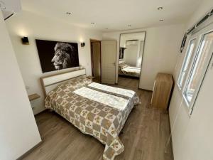 a bedroom with a bed and a tv on the wall at Bas de villa cosy Juan les Pins avec jardin in Juan-les-Pins