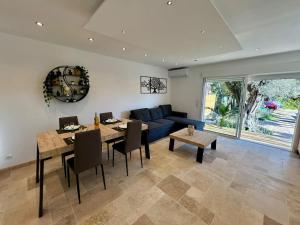 a living room with a blue couch and a table at Bas de villa cosy Juan les Pins avec jardin in Juan-les-Pins