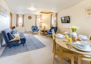 a dining room and living room with a table and chairs at The Corn Bin in Sedlescombe