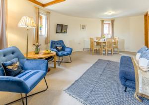 sala de estar con sillas azules y mesa en The Corn Bin en Sedlescombe