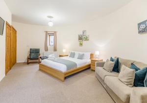 a bedroom with a bed and a couch at The Corn Bin in Sedlescombe