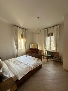 a bedroom with a bed and a table and two windows at Via Creti & Via Mazza Rooms in Bologna