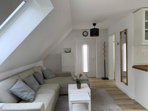 een witte woonkamer met een bank en een tafel bij Haus Lindenstraße 3 