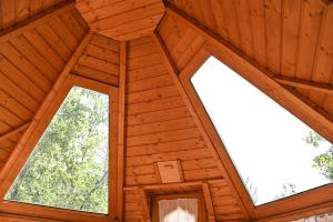 an attic room with a wooden ceiling and two windows at Camping le Colorado in Rustrel