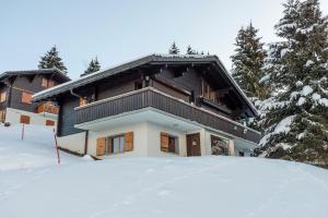 une maison avec de la neige devant elle dans l'établissement Appartement Chantilu, à Les Mosses