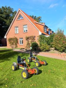 three four wheelers parked in the grass in front of a house at Haus-Auetal 